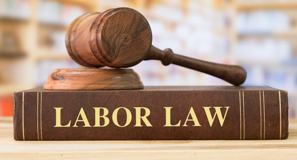Judge's gavel sits on top of a leather-bound book labeled "Labor Law"